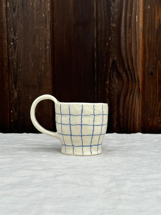 white pinched mug with blue pencil grid