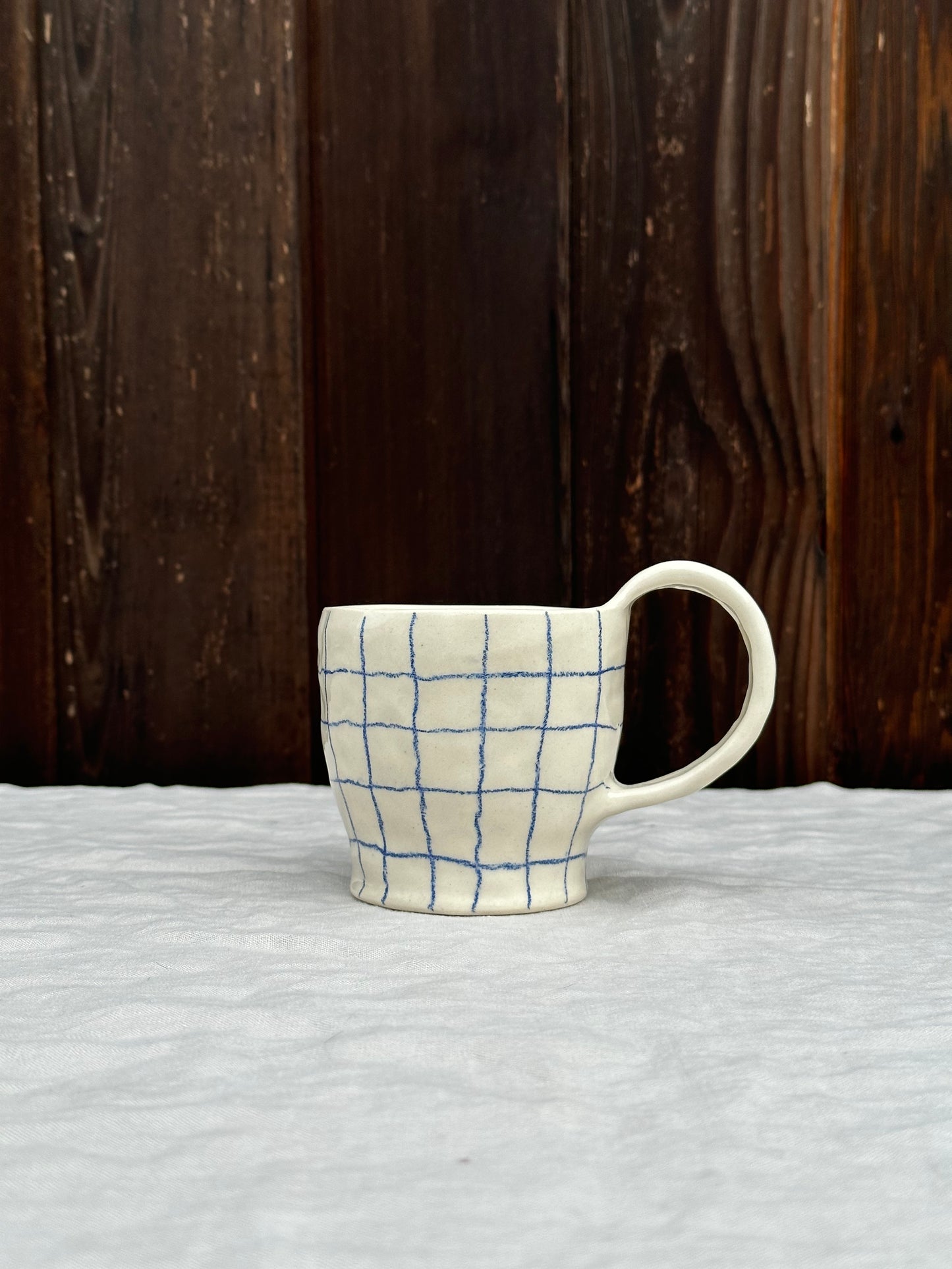 white pinched mug with blue pencil grid