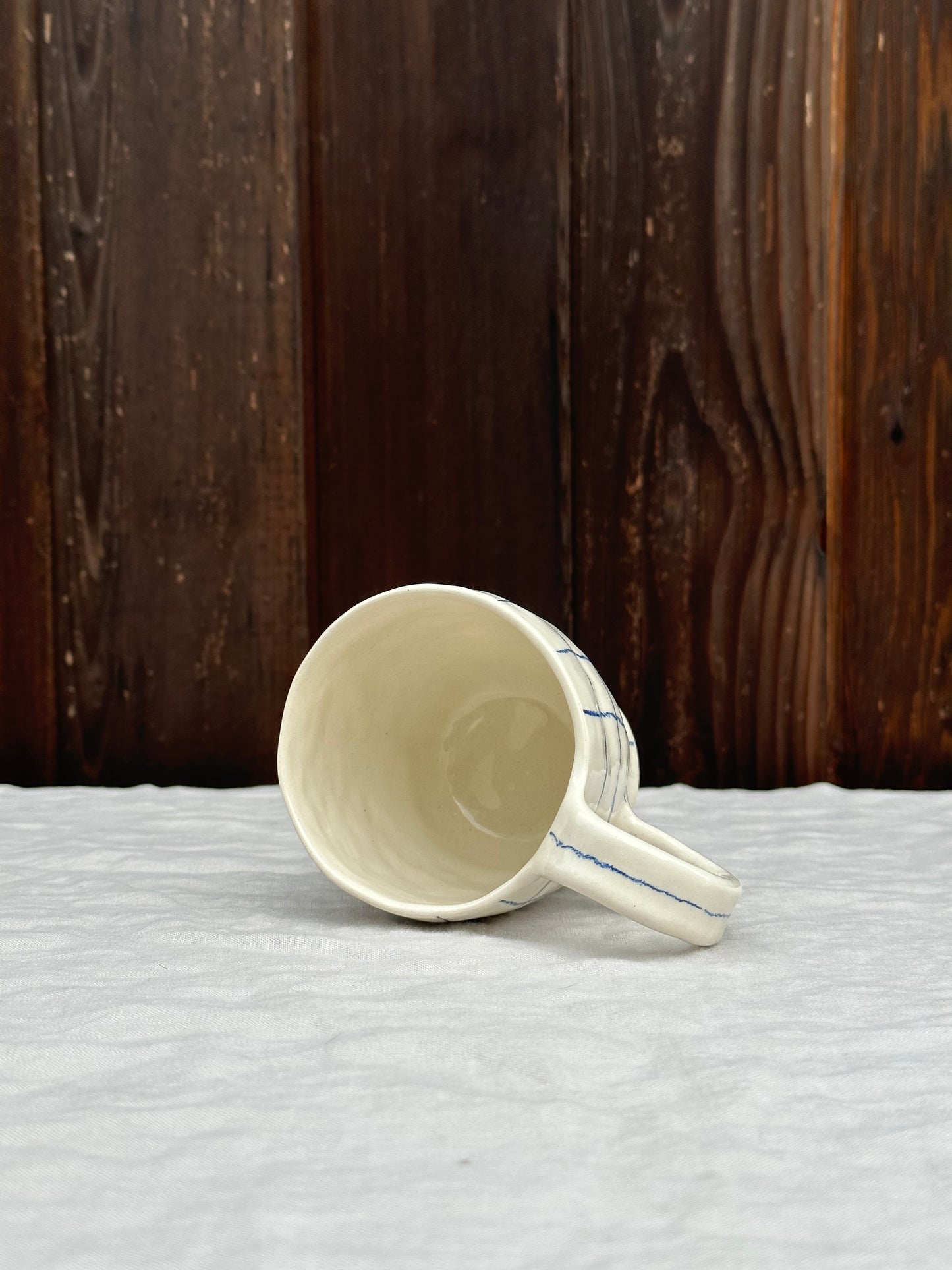 white pinched mug with blue pencil grid