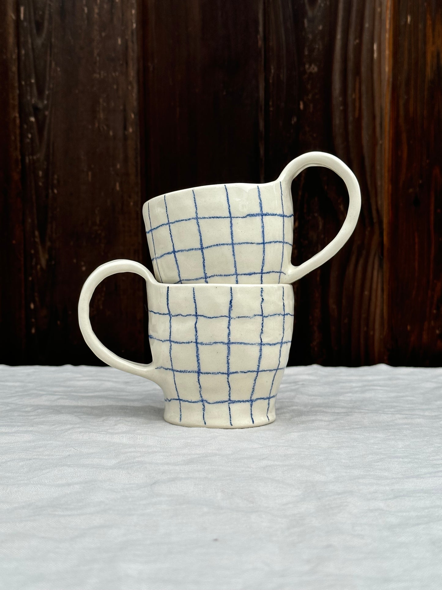 white pinched mug with blue pencil grid