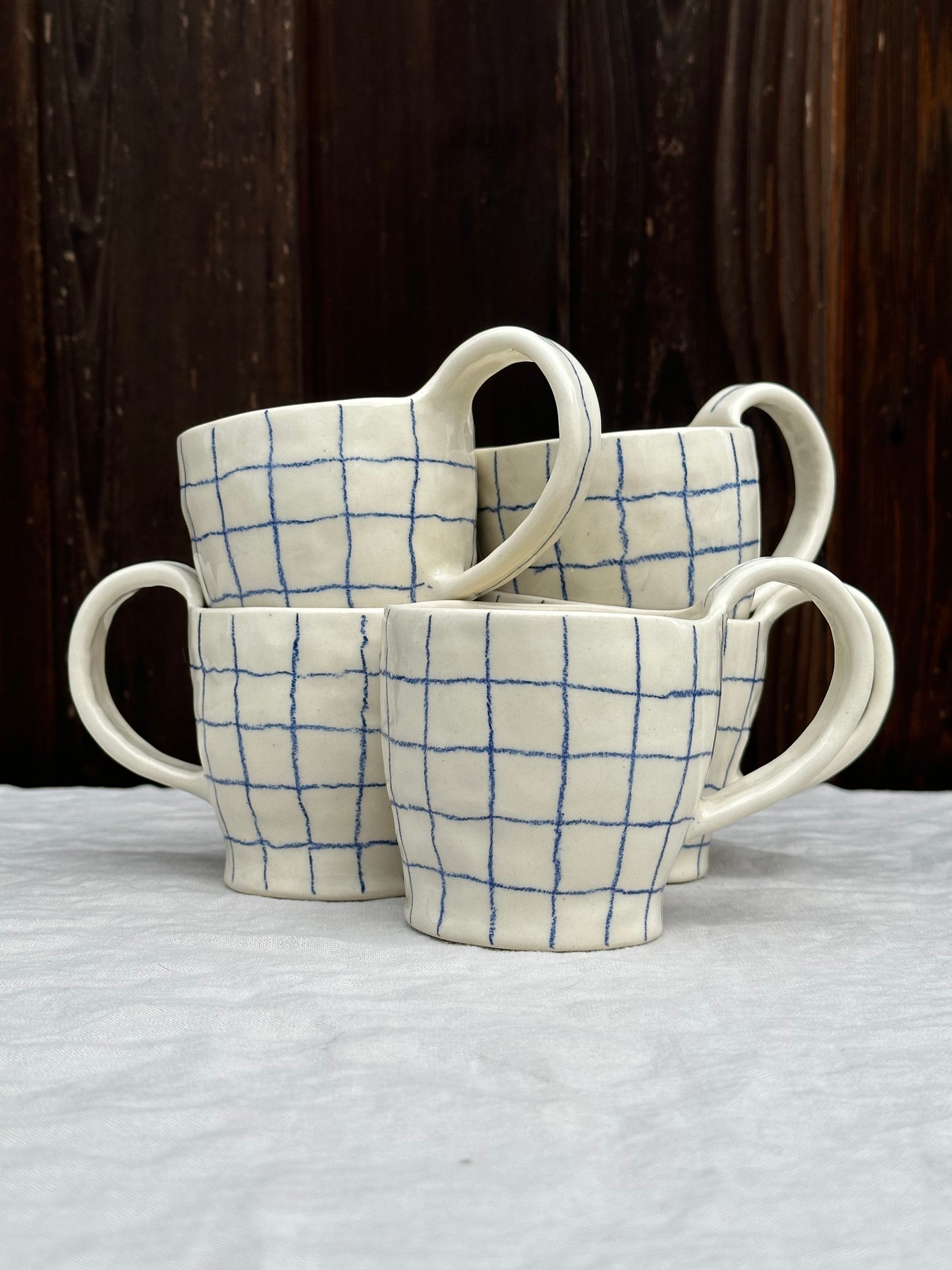 white pinched mug with blue pencil grid